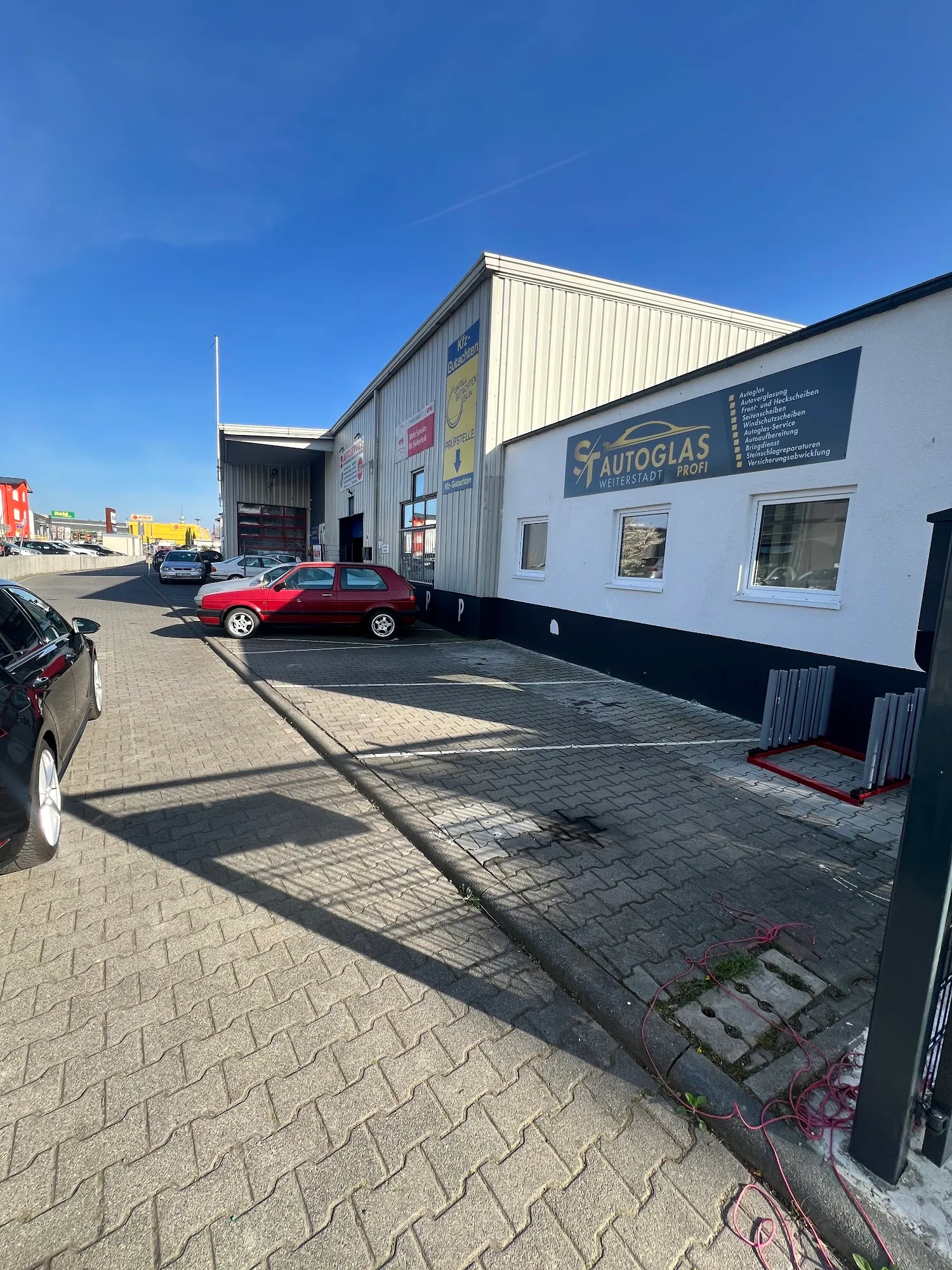 Außenansicht der Werkstatt ST AUTOGLAS Profi mit Firmenbeschilderung in Weiterstadt