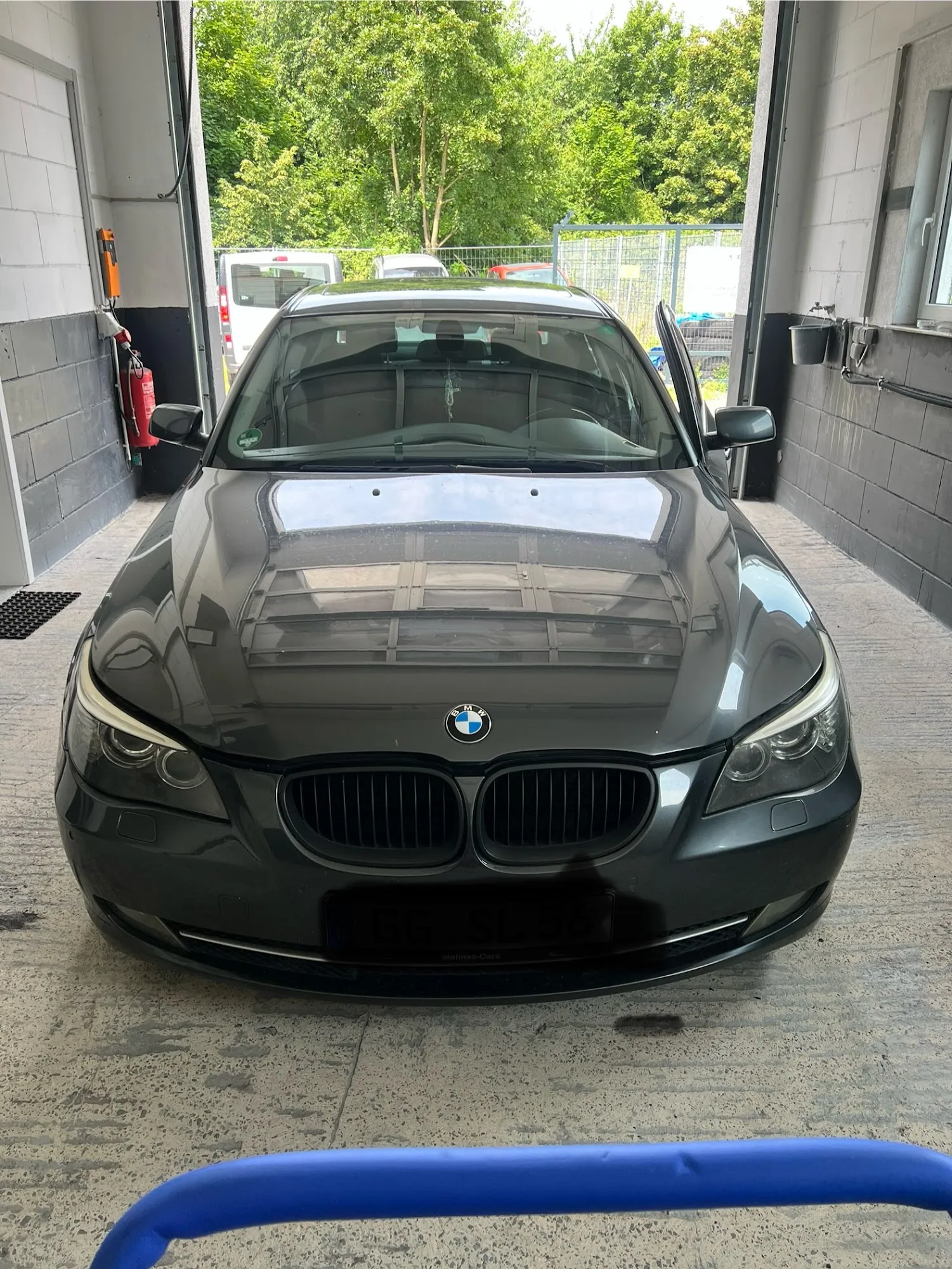 Dunkler BMW nach erfolgreichem Frontscheibentausch in der Werkshalle